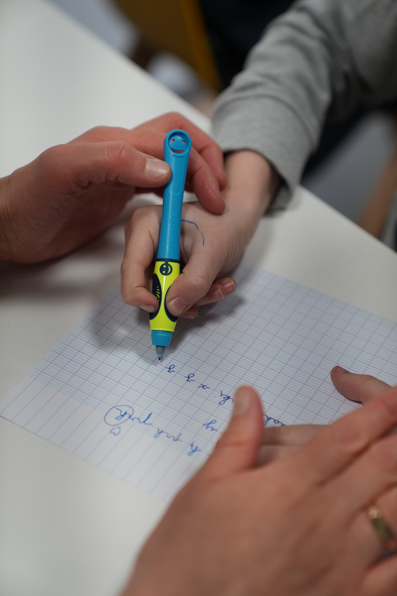Main d'enfant guidée pour bien tenir son crayon ergonomique